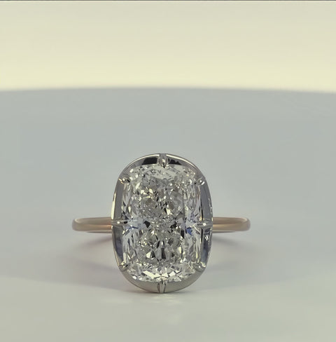 short video of white and yellow gold ring rotating on a white background.