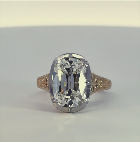 short video of a white and yellow gold ring with a diamond center rotating on a white background. 