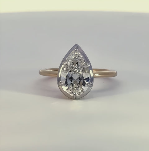 short video of a white and yellow gold ring with a diamond center rotating on a white background.