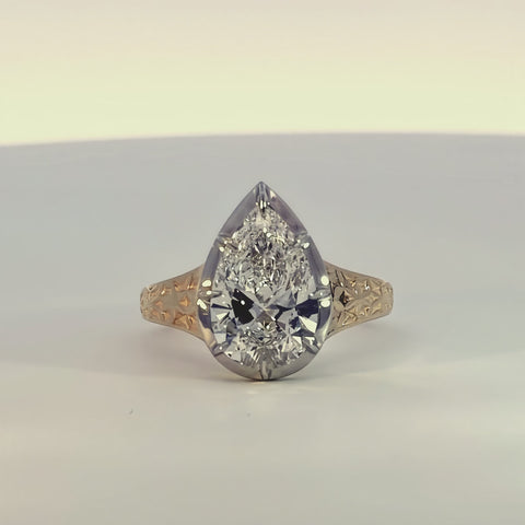 A diamond ring made of 14k white and yellow gold spinning slowly around on a white background.